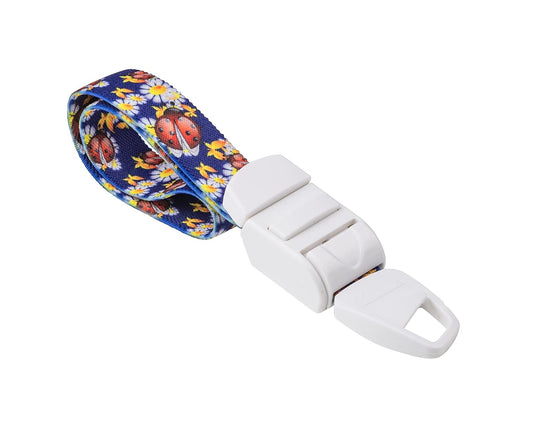 MEDICININIS TURNIKETAS su mėlynu boružėlių raštų dirželiu ir balta sagtele.