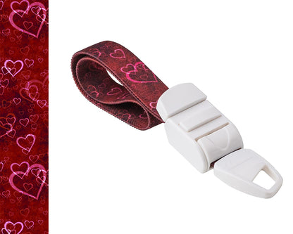 MEDICININIS TURNIKETAS su raudonų širdelių raštų dirželiu ir balta sagtele.  Pateikiamas turniketo juostelės rašto paveikslėlis